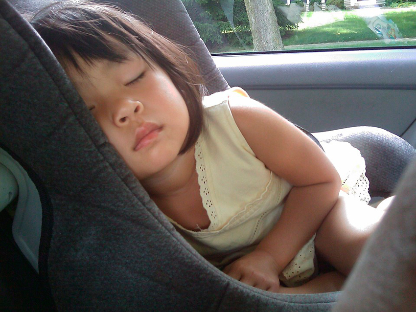 Niña pequeña dormida en el coche